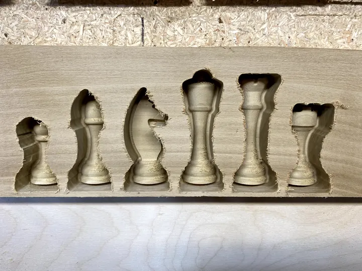 A row of chess pieces carved in a board