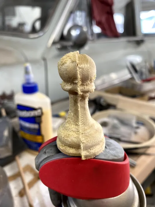 A carved pawn being glued up