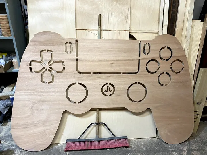 A game-controller shape cut from plywood