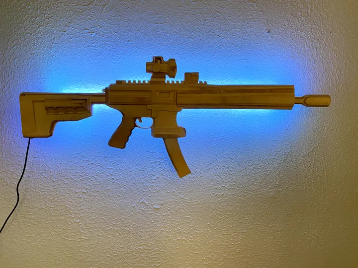 The wooden rifle replica on a wall with blue LED backlight