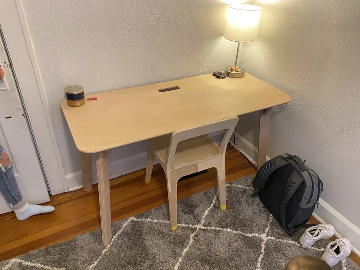 A plywood desk and chairs in a home office